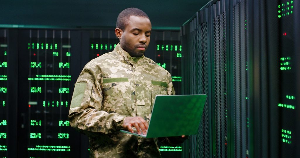 一名非裔美国男性军官穿着制服站在电脑前