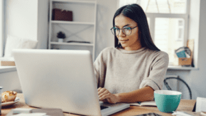 young woman working on her laptop at her home office