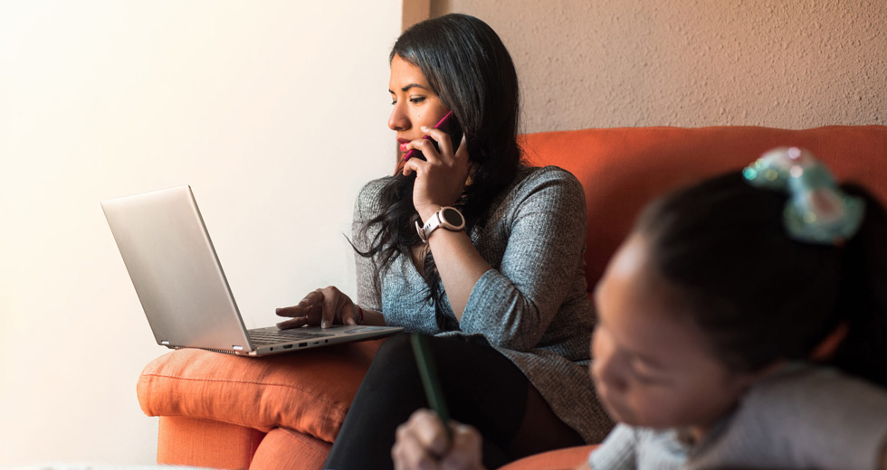 Woman On Phone and Laptop As Her Child Plays, Example of Poor Work-Life Balance