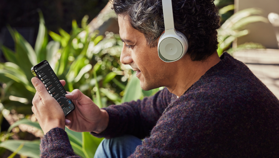 Man on phone wearing Cisco headsets looking at Webex