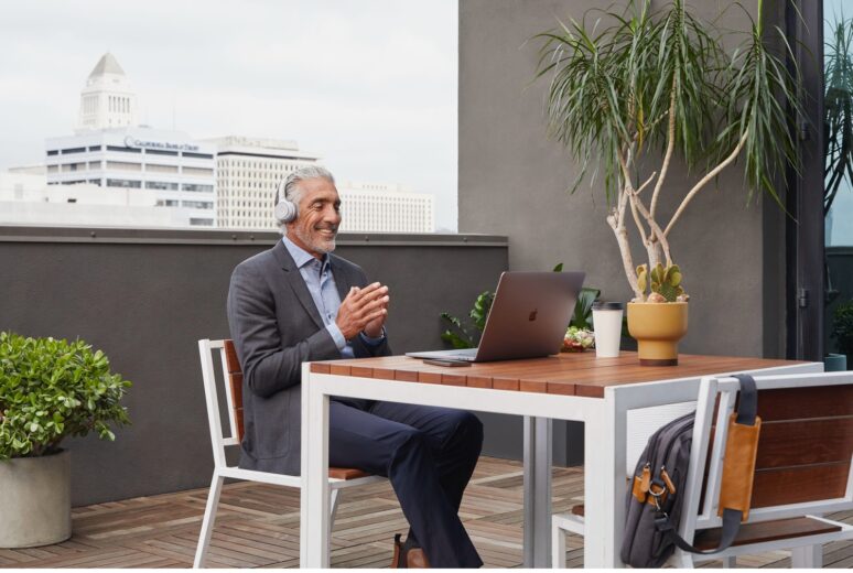 Mann mit Cisco-Headset sitzt draußen auf dem Balkon