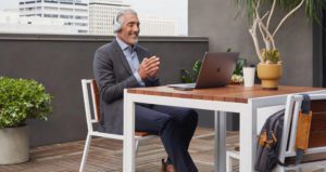 Man sitting outside on balcony wearing Cisco headsets