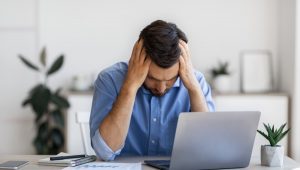 Man In Hybrid Work Office With Hands On His Head