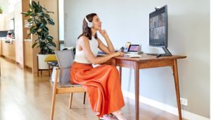 Woman sitting at home office wearing headsets