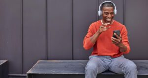 Man Sitting On Bench Using Iphone With Webex Calling