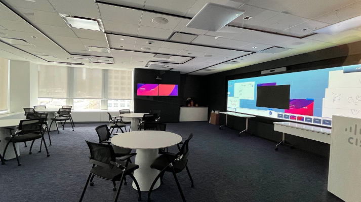 An office space setup for collaboration -- complete with touchscreen video conferencing monitors