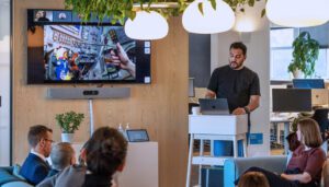 Several members of the Designit team meeting in their office, with others video conferencing in.