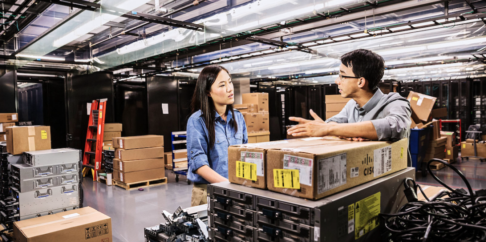 Two people in a Cisco warehouse