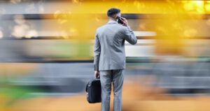 Man On Phone Standing Infront Of Multiple Distractions Feature